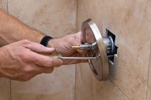 Plano TX plumbing contractor repairs a shower knob with a phillips head